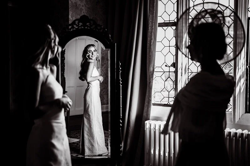 Portrait of the bride, Kat in the mirror with her mum as a silhouette at Eastwell Manor, Kent