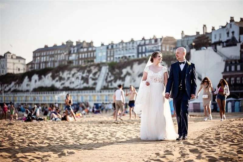Colour photo of the bride and groom walking on the beach during their portrait session. Matt Rock Photography - Kent wedding photographer