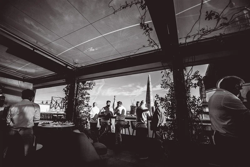 Black & White photo on top of the Wagtail Rooftop Bar & Restaurant of guests of SEC with The Shard in the background