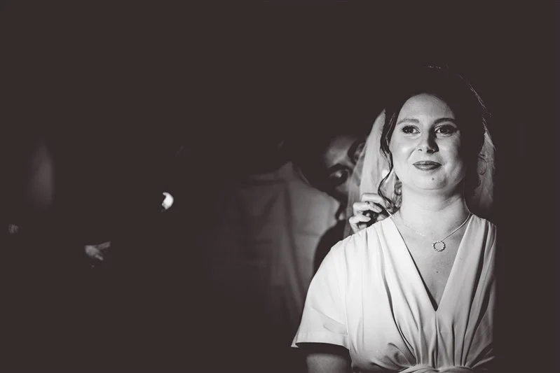 Black & White photo of the bride having her hair and make up finished off  - in her wedding dress. The Oak Barn, Frame Farm.