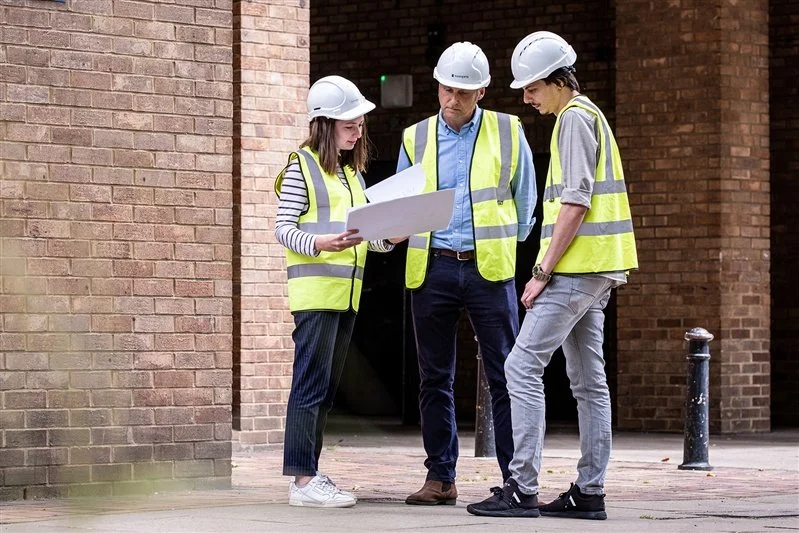 Commercial shoot for a London based surveyors - photo of a group of surveyors looking at plans outside a building. 