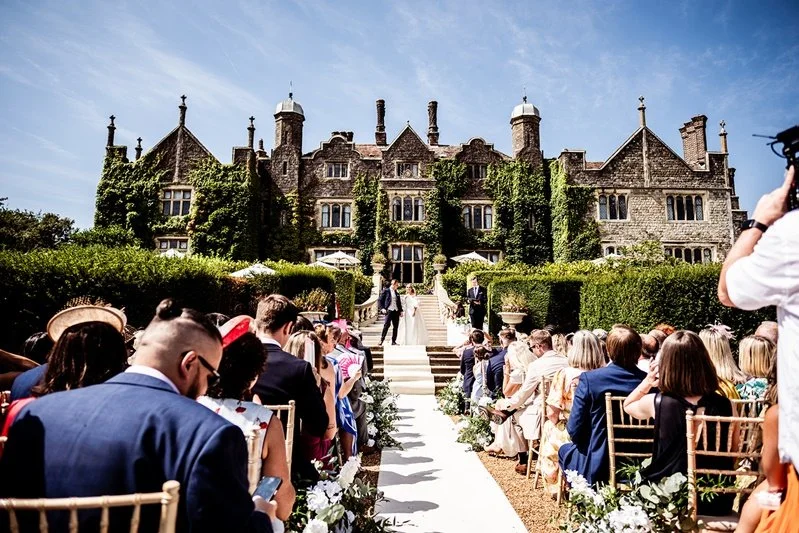 Colour photo of the ceremony with Eastwell Manor in the background