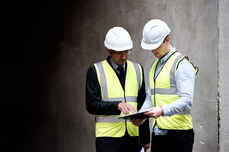 Commercial shoot with two surveyors discussing plans outside in London UK