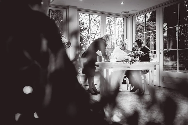 Black & White photo of the bride and groom signing their marriage certificate at Hayne House.