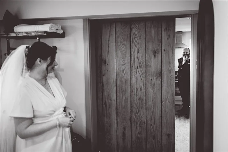 Black & White photo Father of the bride waiting to see his daughter for the first time in her wedding dress. The Oak Barn, Frame Farm.