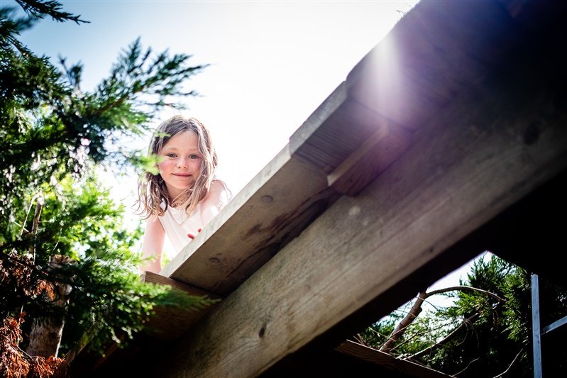 cOLOUR PHOTO OF A GIRL CLIMBING A TREE HOUSE