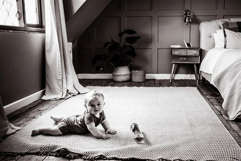 Black & White photo of a baby crawling on the carpet