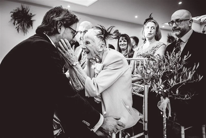 A beautiful black & white photo of the moment the grooms mum congratulates her son at Hayne House