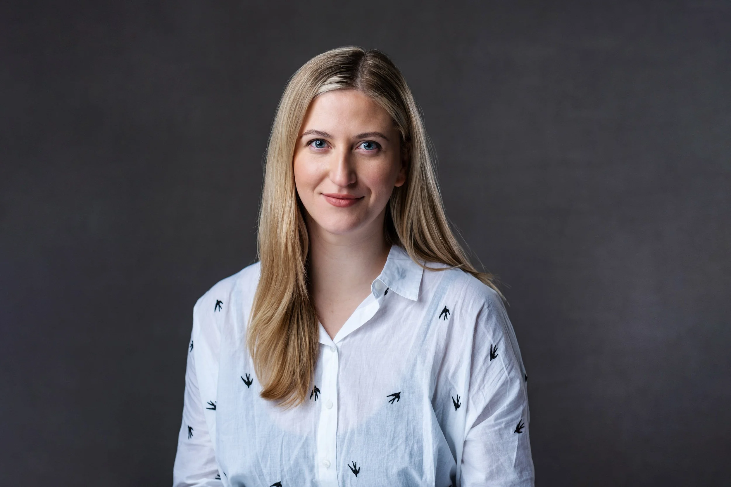 Headshot of a lady in a white shirt with a grey background shot on location in London - Portrait Photographer Matt Rock