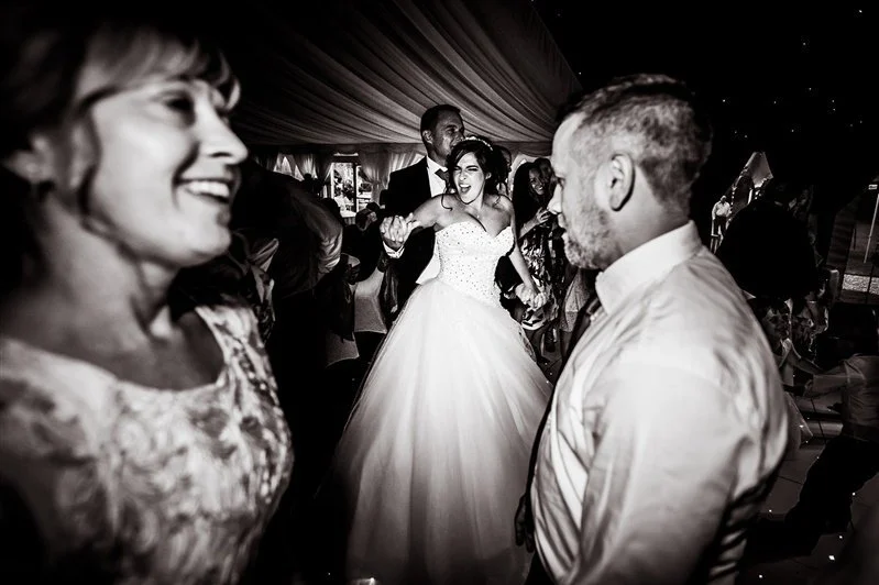Bride dancing on the dance floor with guests all around her at Westenhanger Castle.