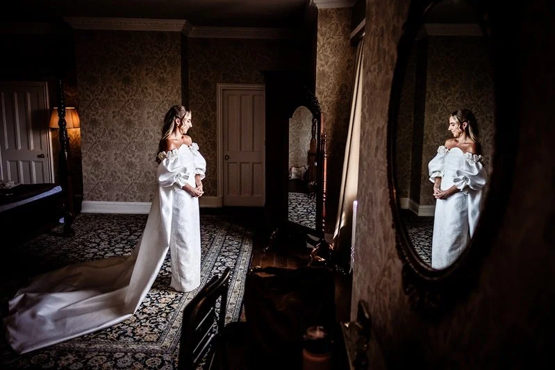 Colour Portrait of the bride, Kat with her reflection in the mirror at Eastwell Manor, Kent