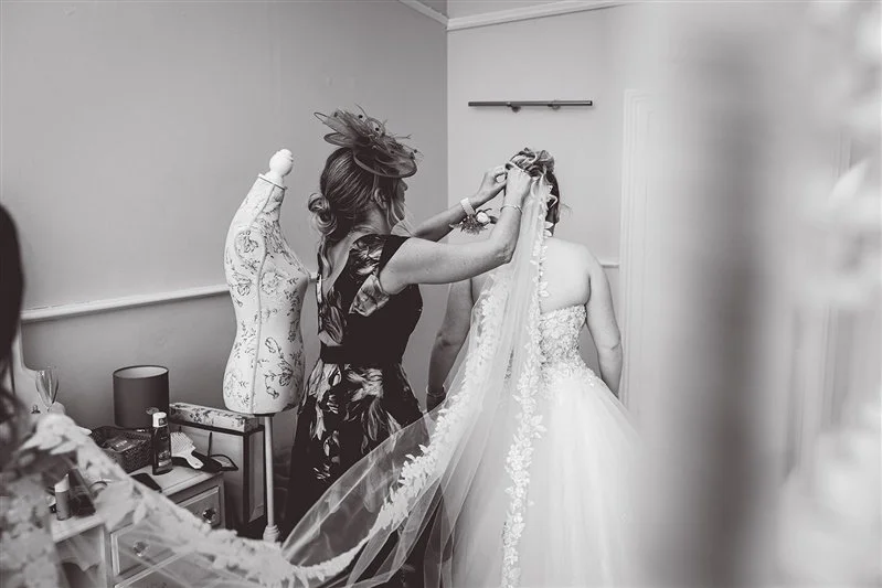Bride and her mum getting the finishing touches to her dress.