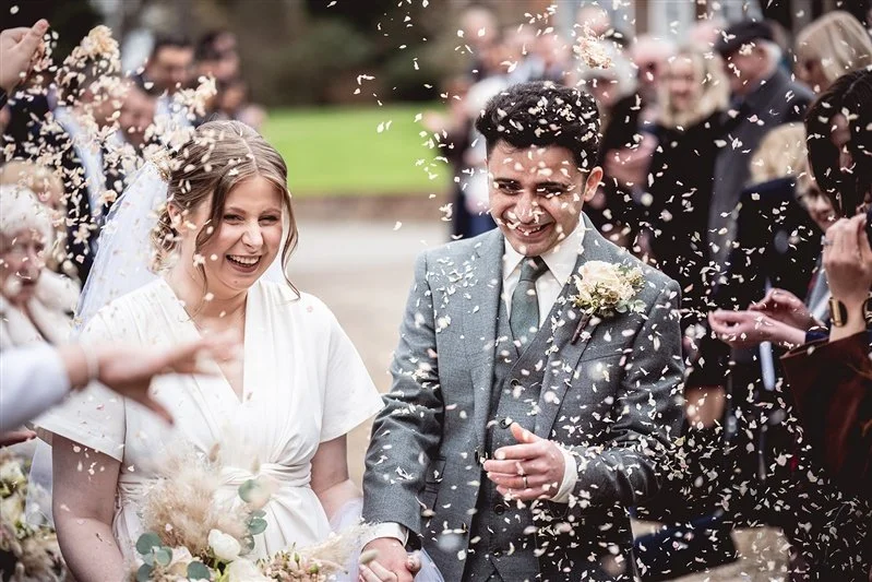 colour photo of the bride and groom and confetti at The Oak Barn, Frame Farm - Kent