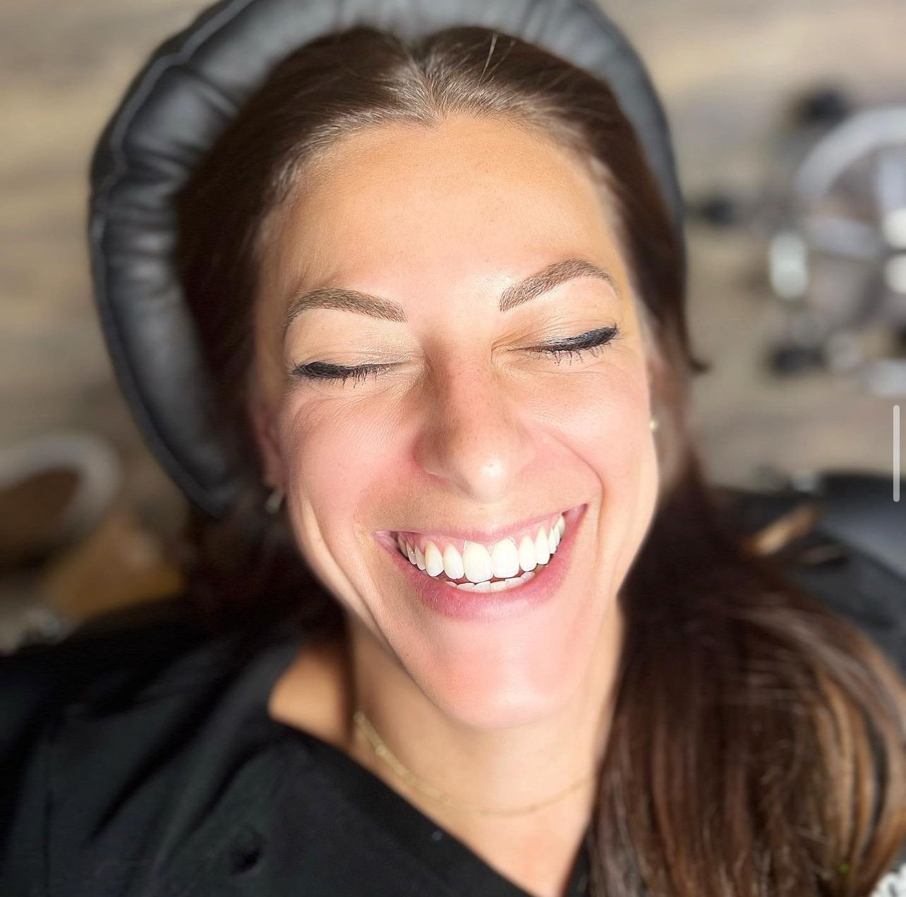 Smiling client with newly microbladed brows, styled to enhance her natural features.