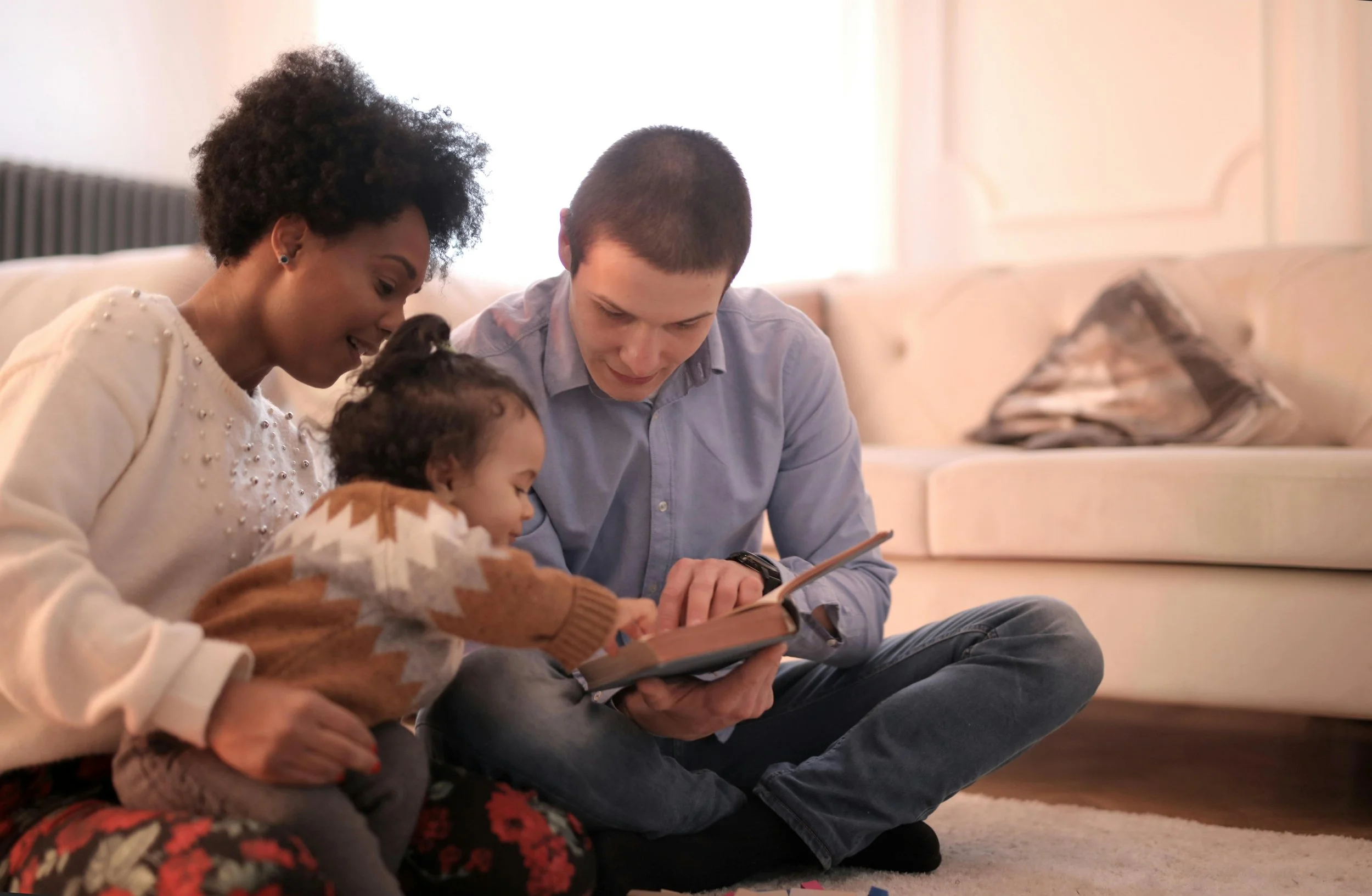 Parents and young child sharing a picture book together