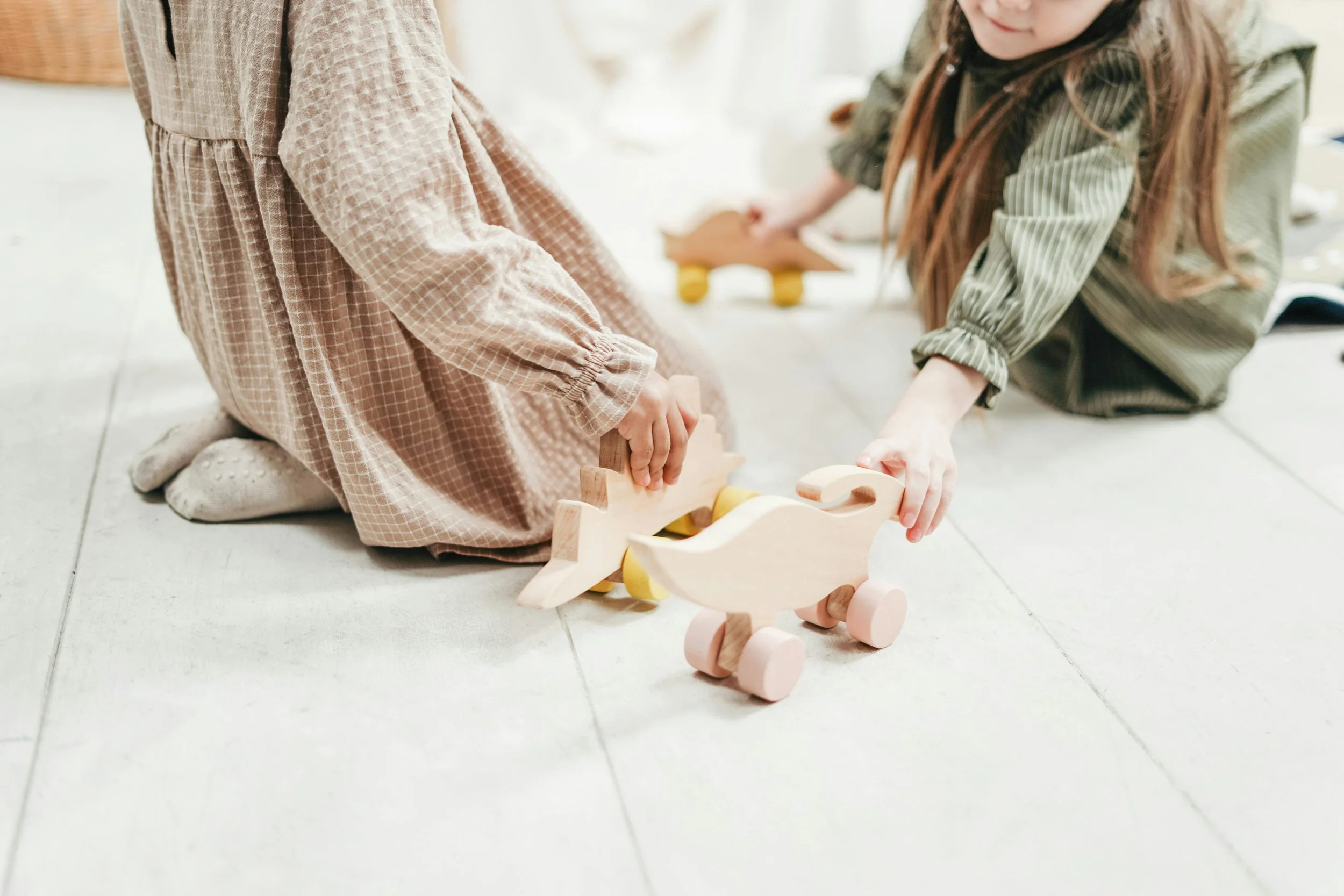 Child and adult playing together with toys on the floor