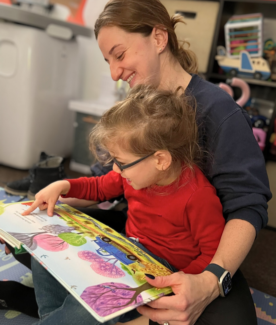 Sam reading a picture book with a child during an in-home speech therapy session