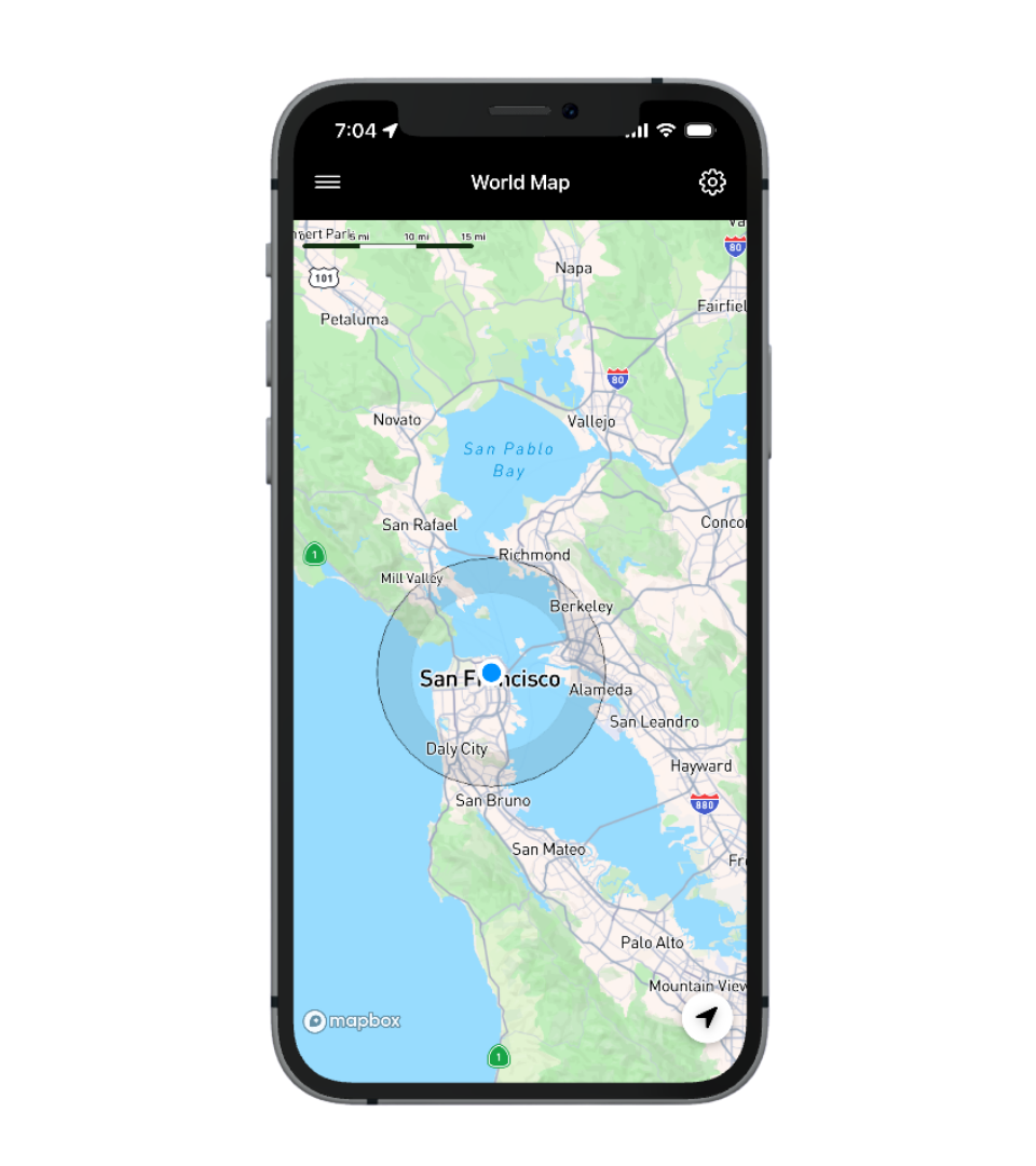 Smartphone displaying a world map centered on the San Francisco Bay Area, with a blue dot indicating the current location and a circular region around it.