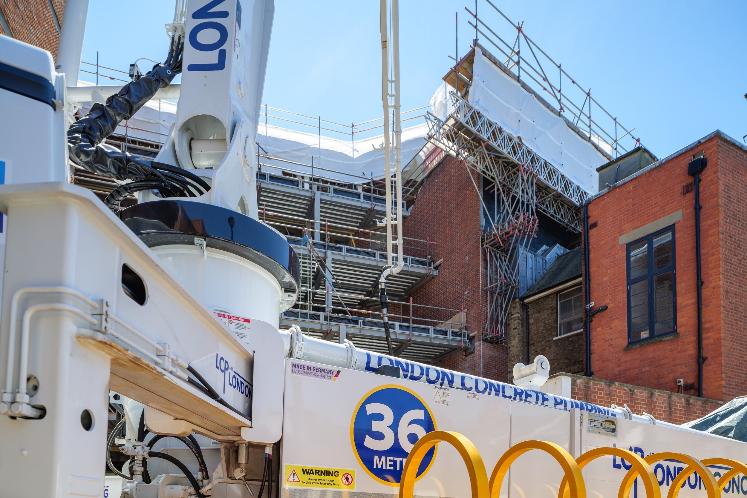 Concrete pump truck at construction site with scaffolding