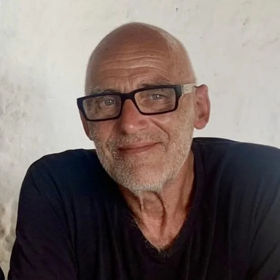 Bald man with glasses and a leather jacket.