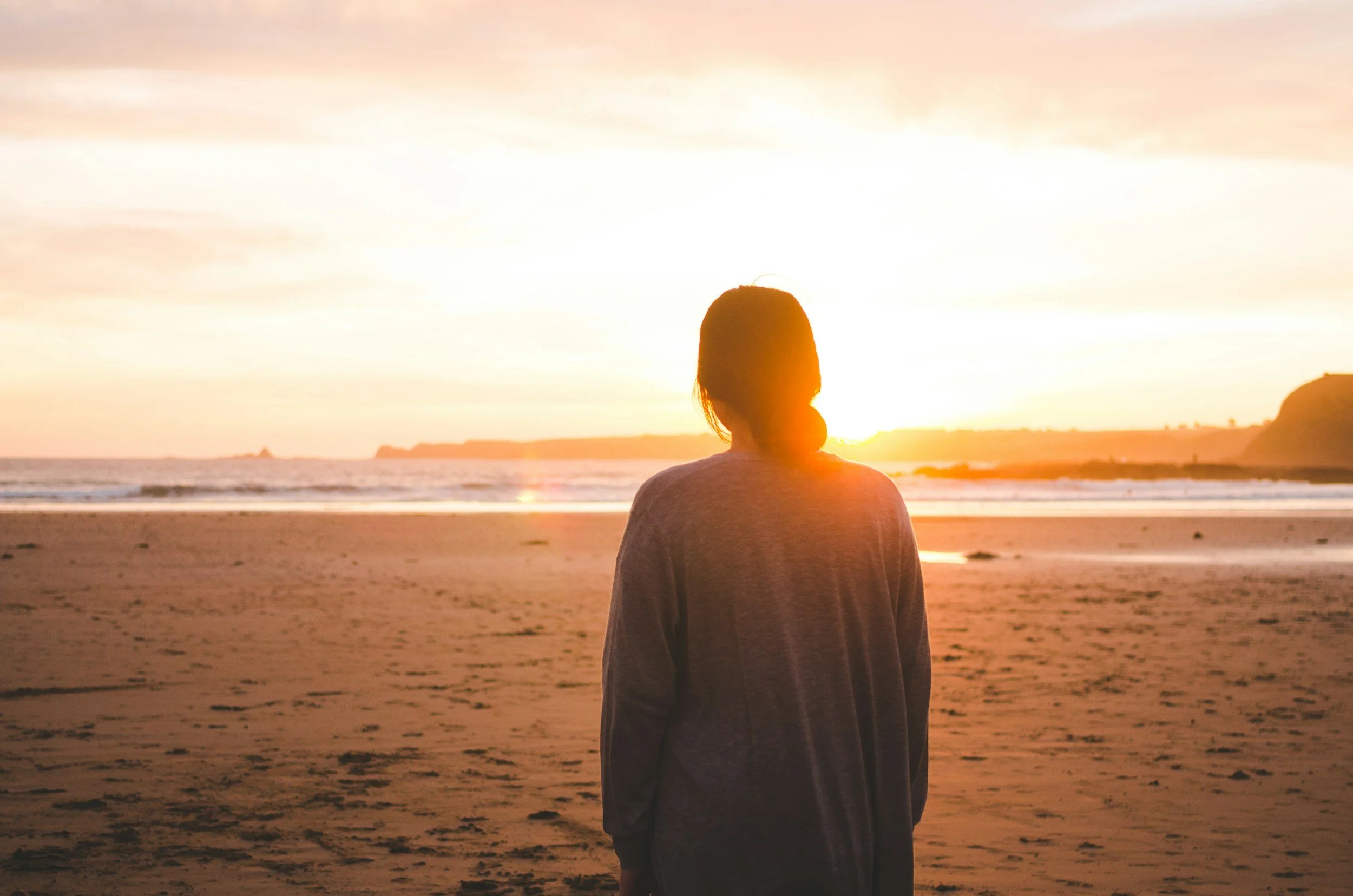 Woman facing ocean and reflecting on her life
