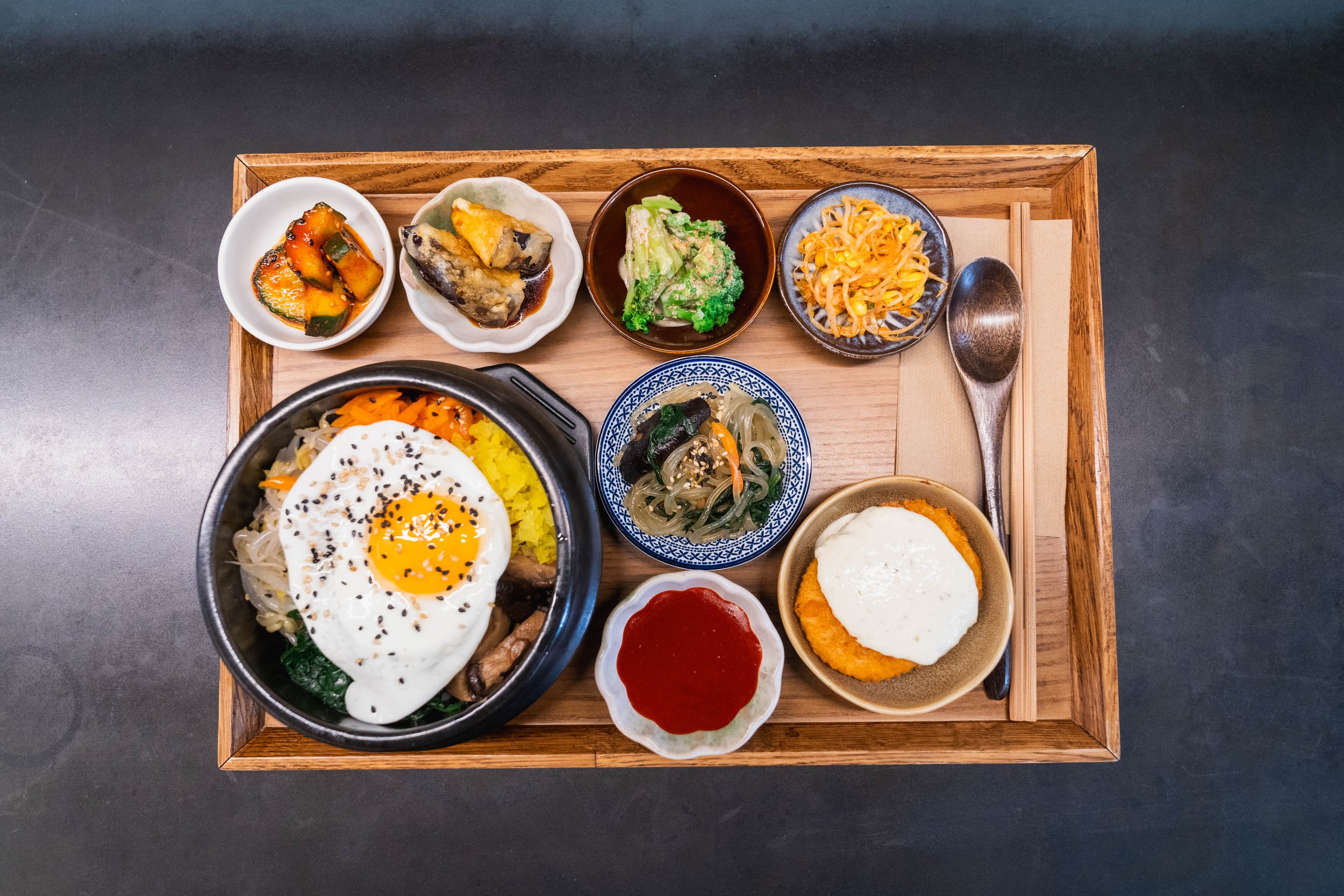 Spicy grilled O-Sam at WATDA, featuring calamari, premium pork, seasonal vegetables, perilla leaves, and gochujang sauce, served with DIY seaweed rice balls.