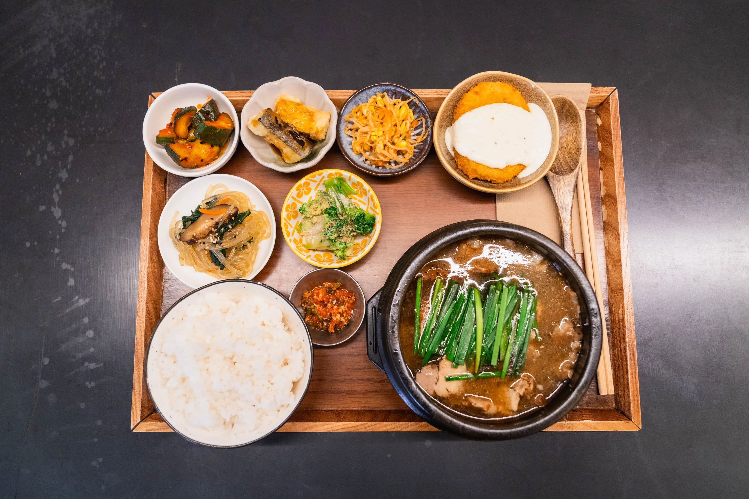 Cold ramen noodles with grilled chicken at WATDA, served with sesame, soy broth, chili, perilla leaves, cucumber, pickled radish, and seaweed.