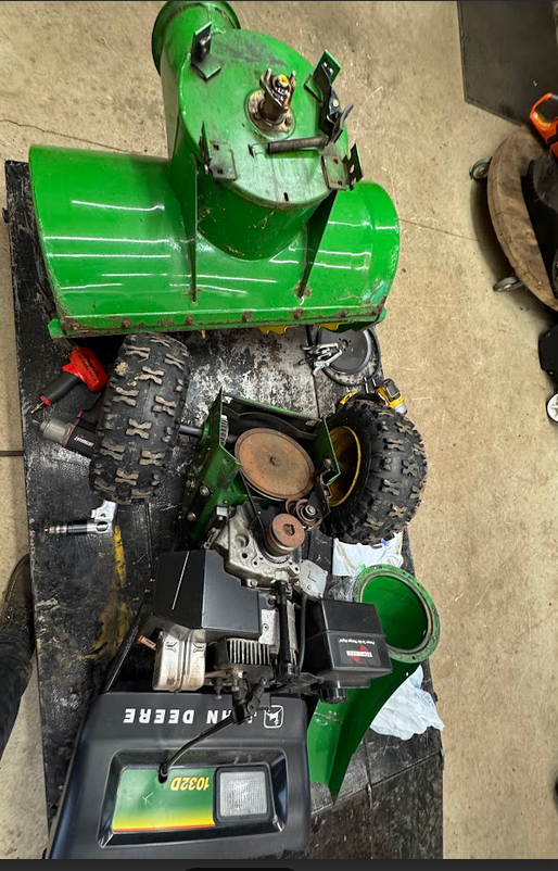 Disassembled john deere snowblower, replacing auger parts and belts.