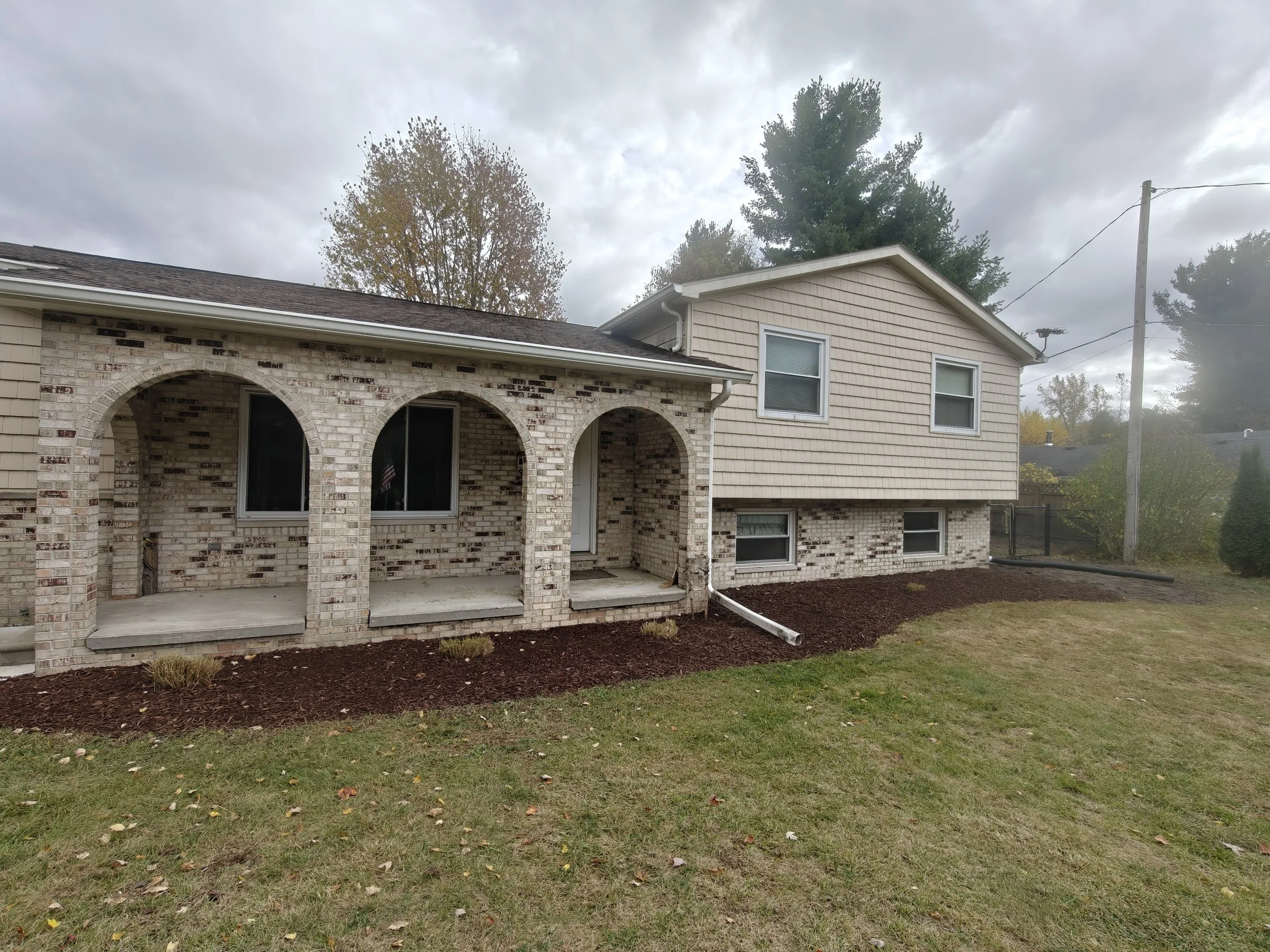 Completed GGL bed reset with clean edges and fresh mulch along a home