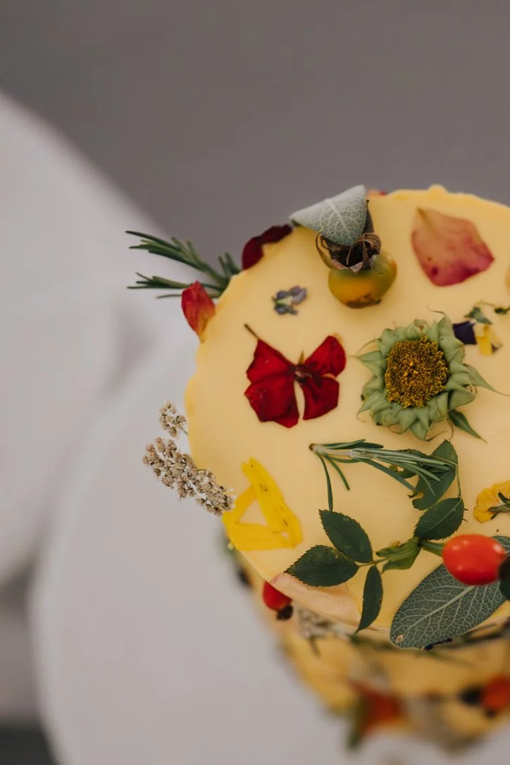 Nahaufnahme einer Hochzeitstorte mit essbaren Blumen.