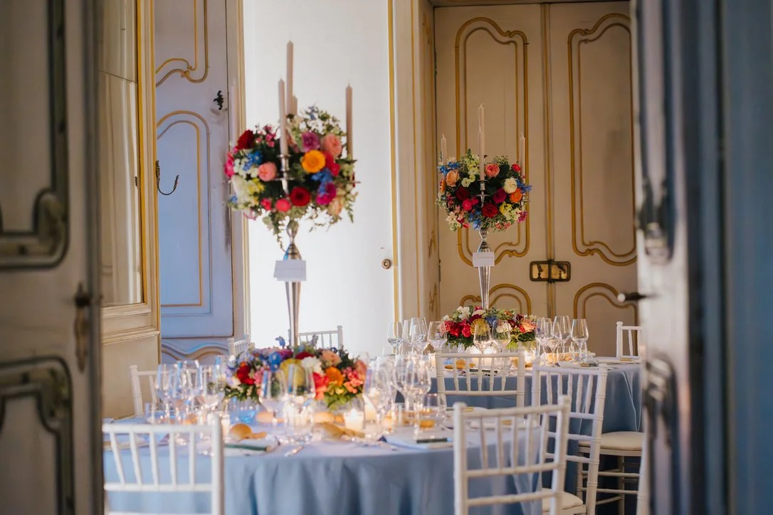 Elegant gedeckter Festtisch mit Blumendekorationen und Kerzen in einem festlichen Raum.