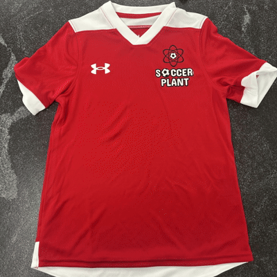 Red soccer jersey with white accents, Under Armour logo, and 'Soccer Plant' logo with atomic symbol.