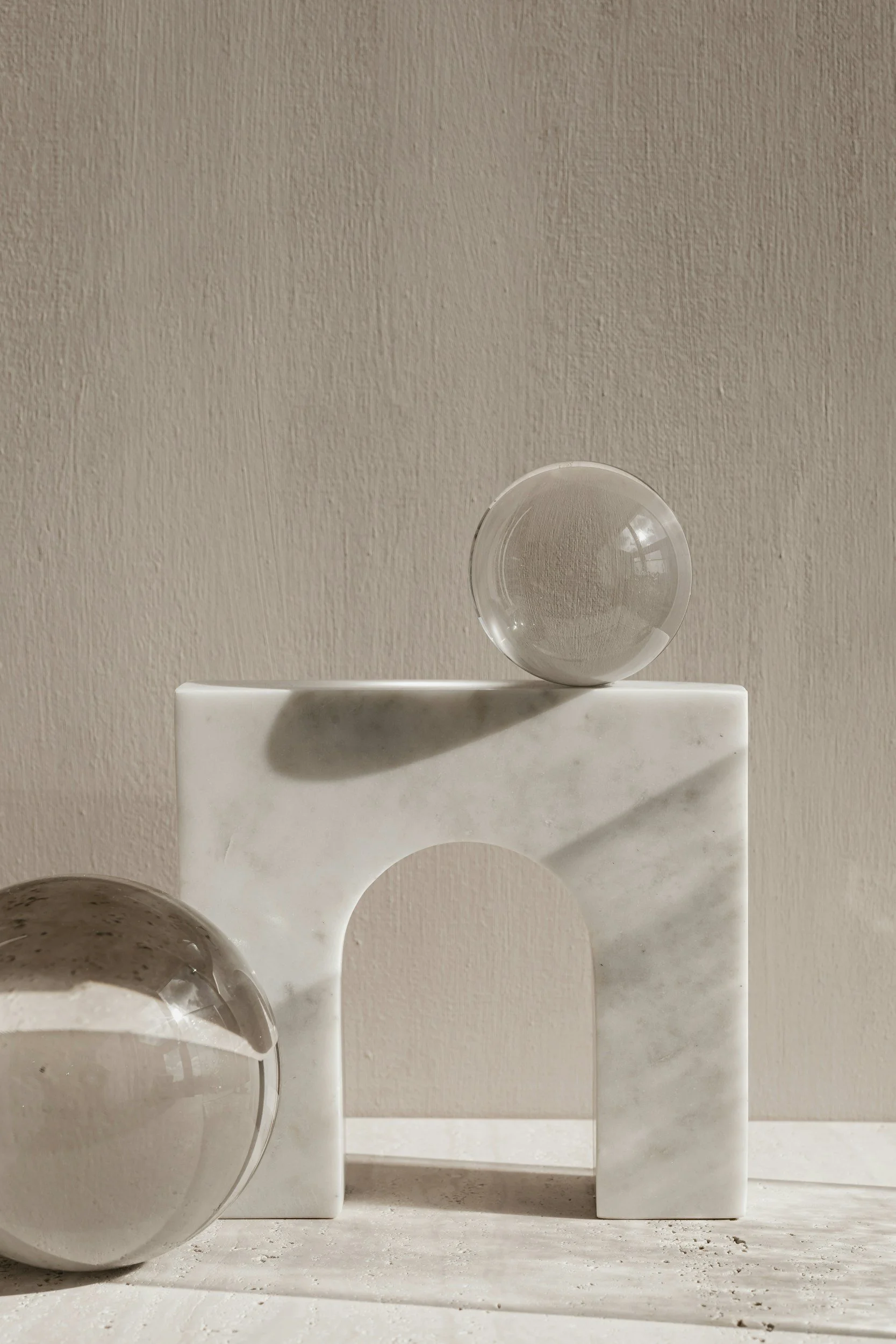 A collection of white marble geometric blocks and cups arranged on a surface and a wall background.