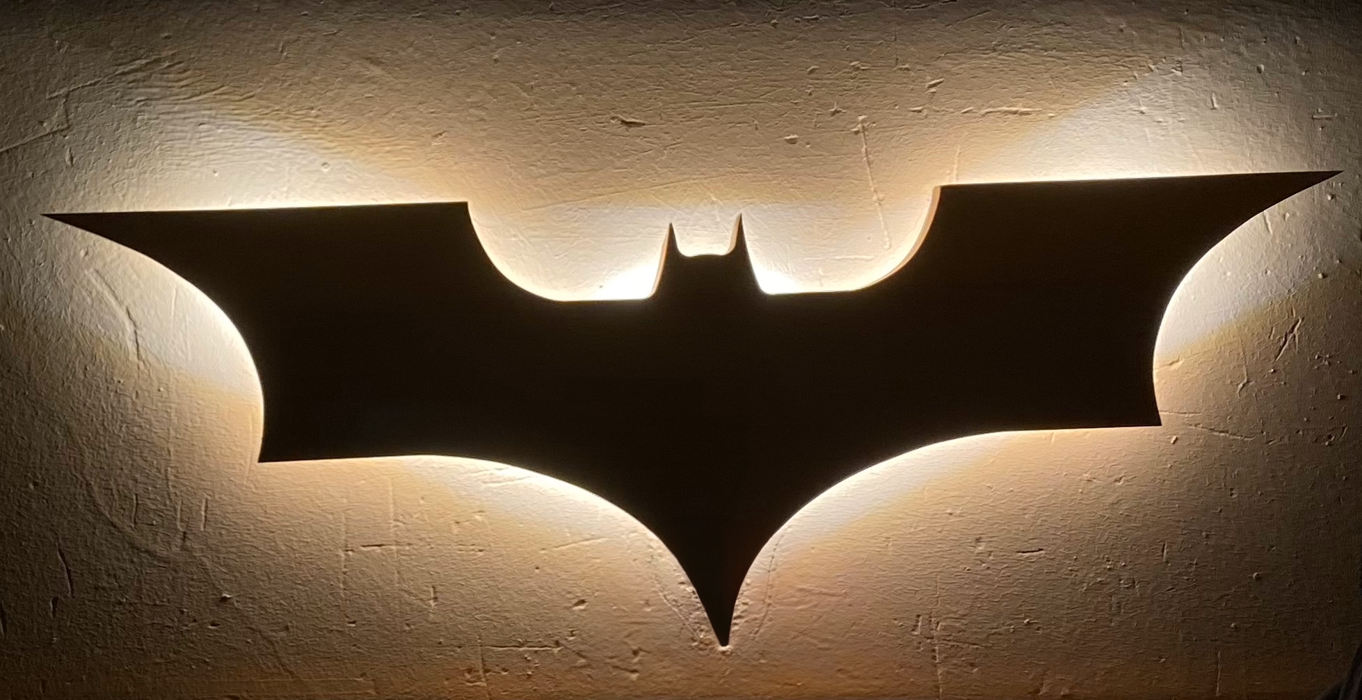 Lámpara de pared con el símbolo de Batman con iluminación trasera.