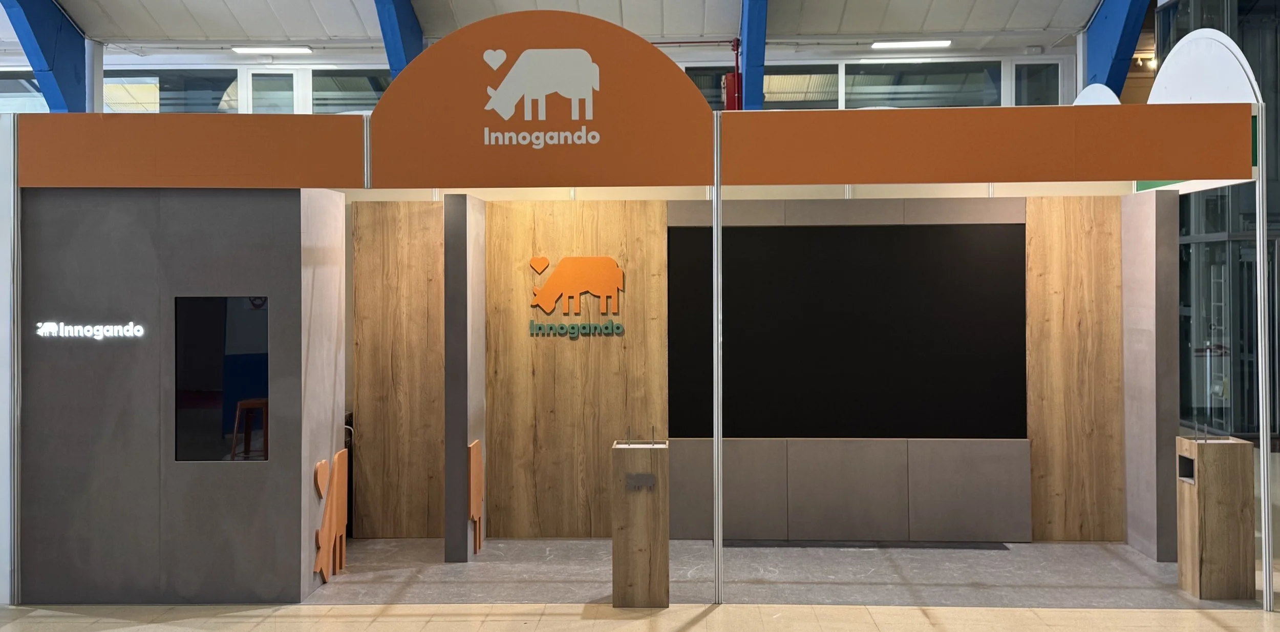 Mostrador de atención con cartel de color naranja y logotipo de una vaca con corazón arriba y la palabra 'Innogando'