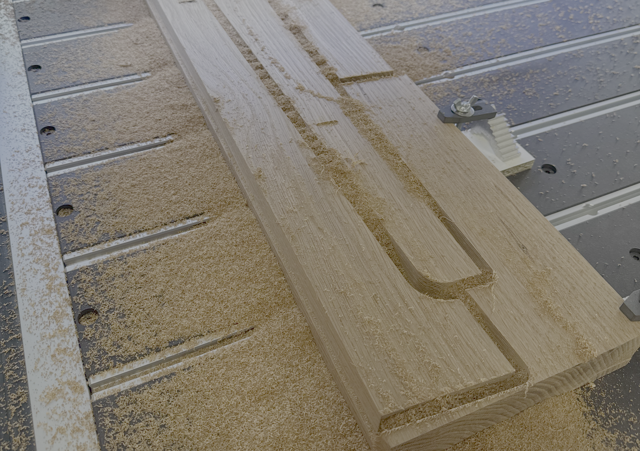 Pieza de madera con restos de virutas en una máquina eléctrica.