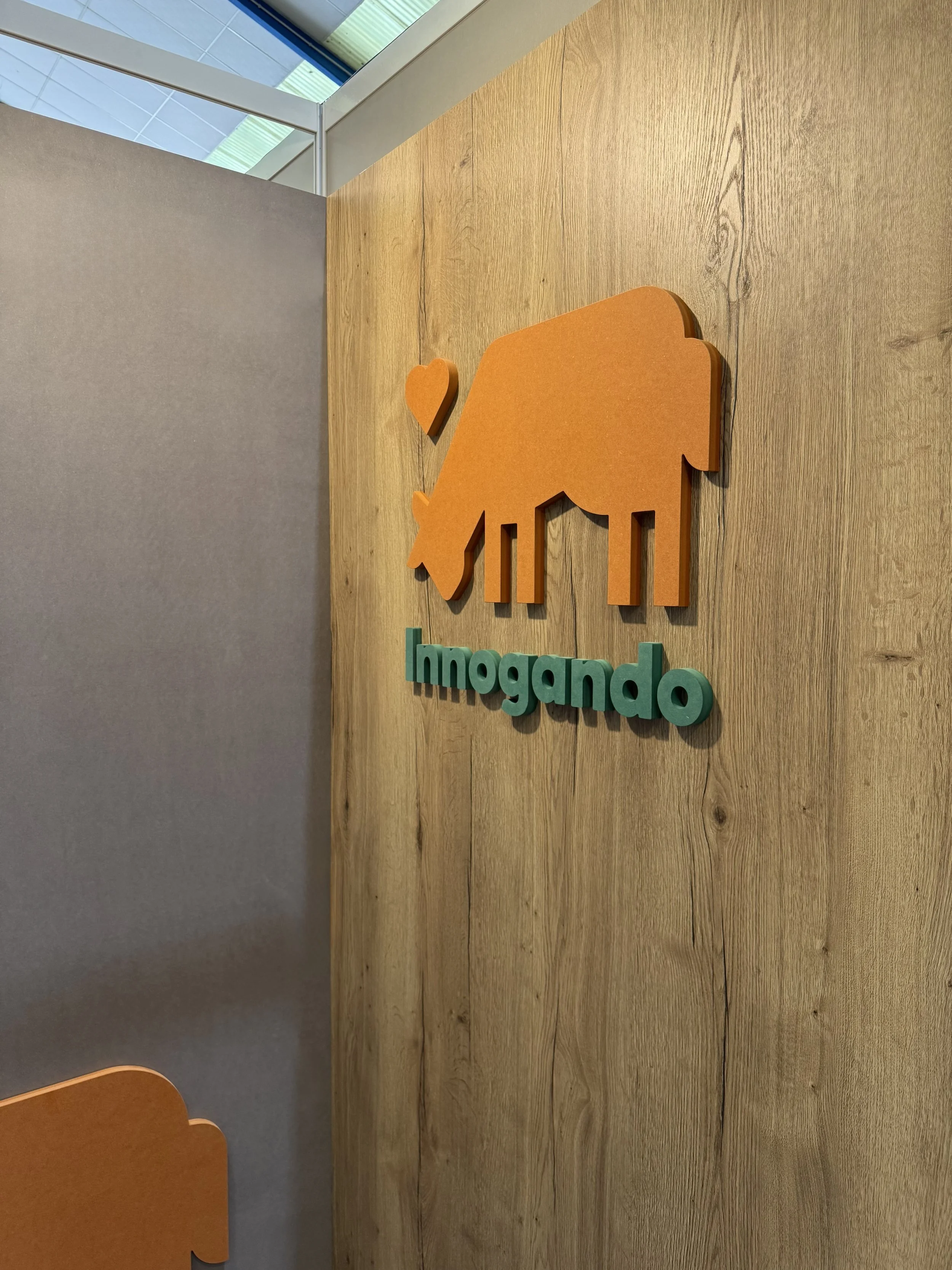 Logotipo de Innogando, que incluye una figura de vaca de color naranja y una pequeña figura de corazón a la izquierda