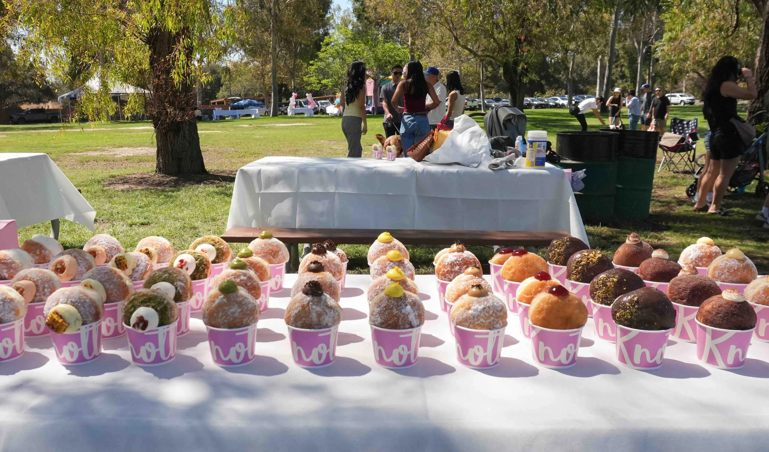 Donut cups lined up on outdoor event tables