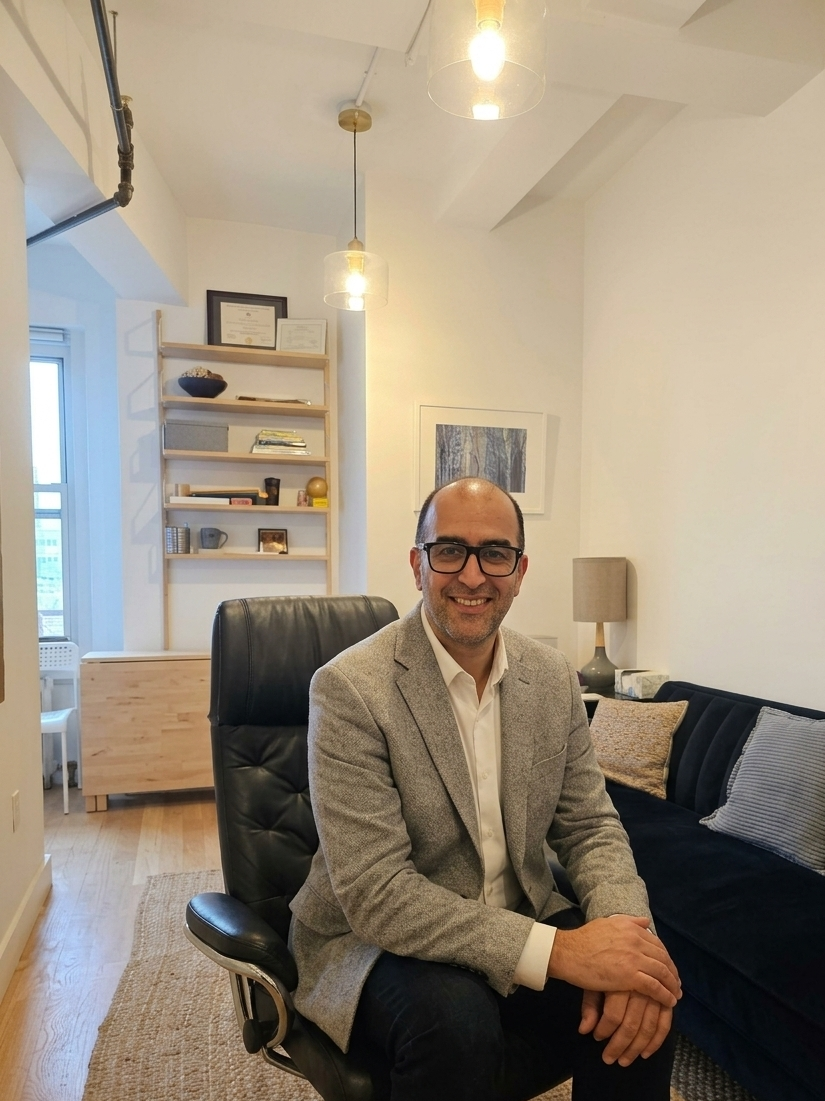Dr. Aaron A. Gubi seated in his Brooklyn Heights therapy office