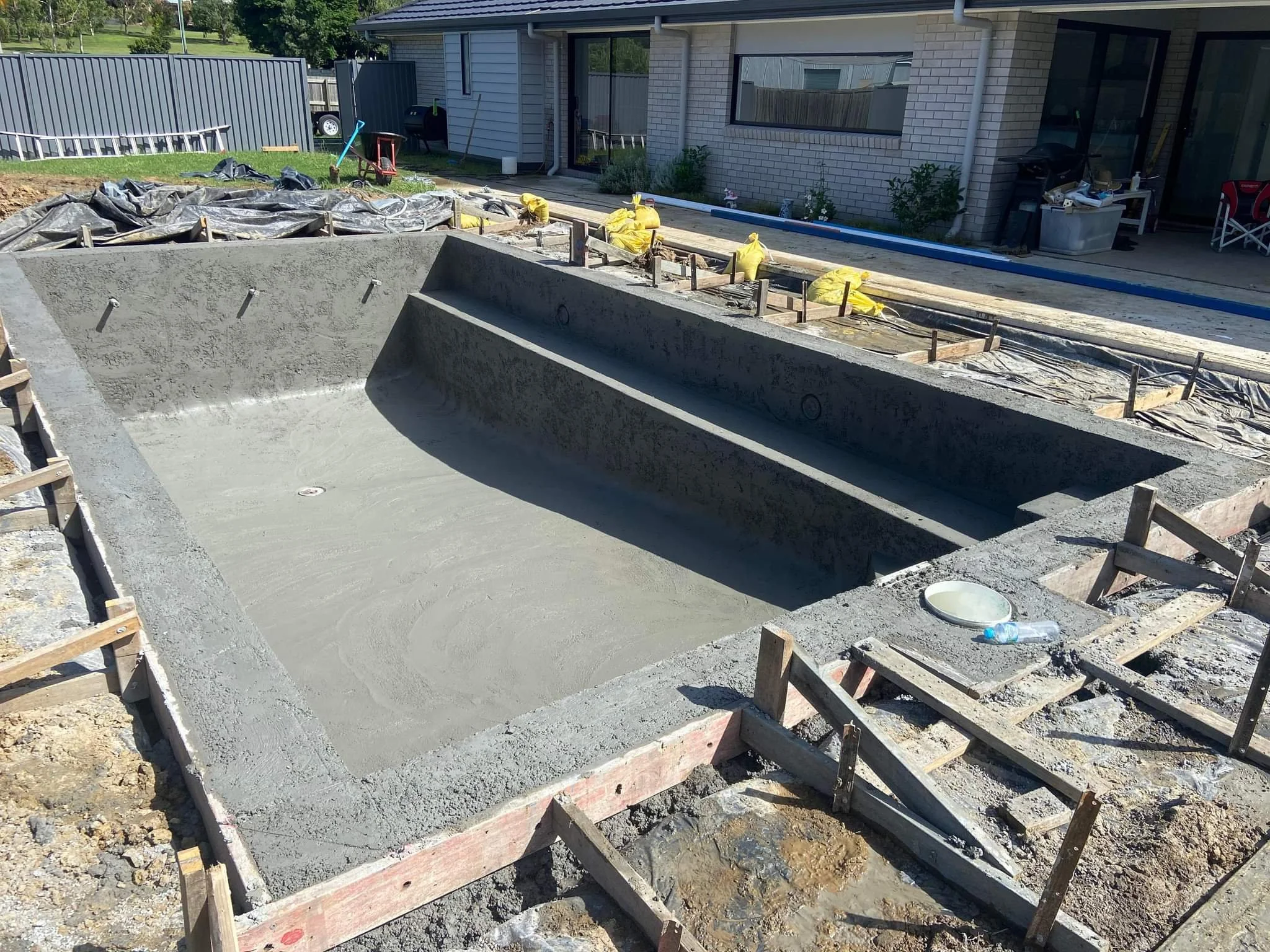 Concrete swimming pool under construction in a backyard