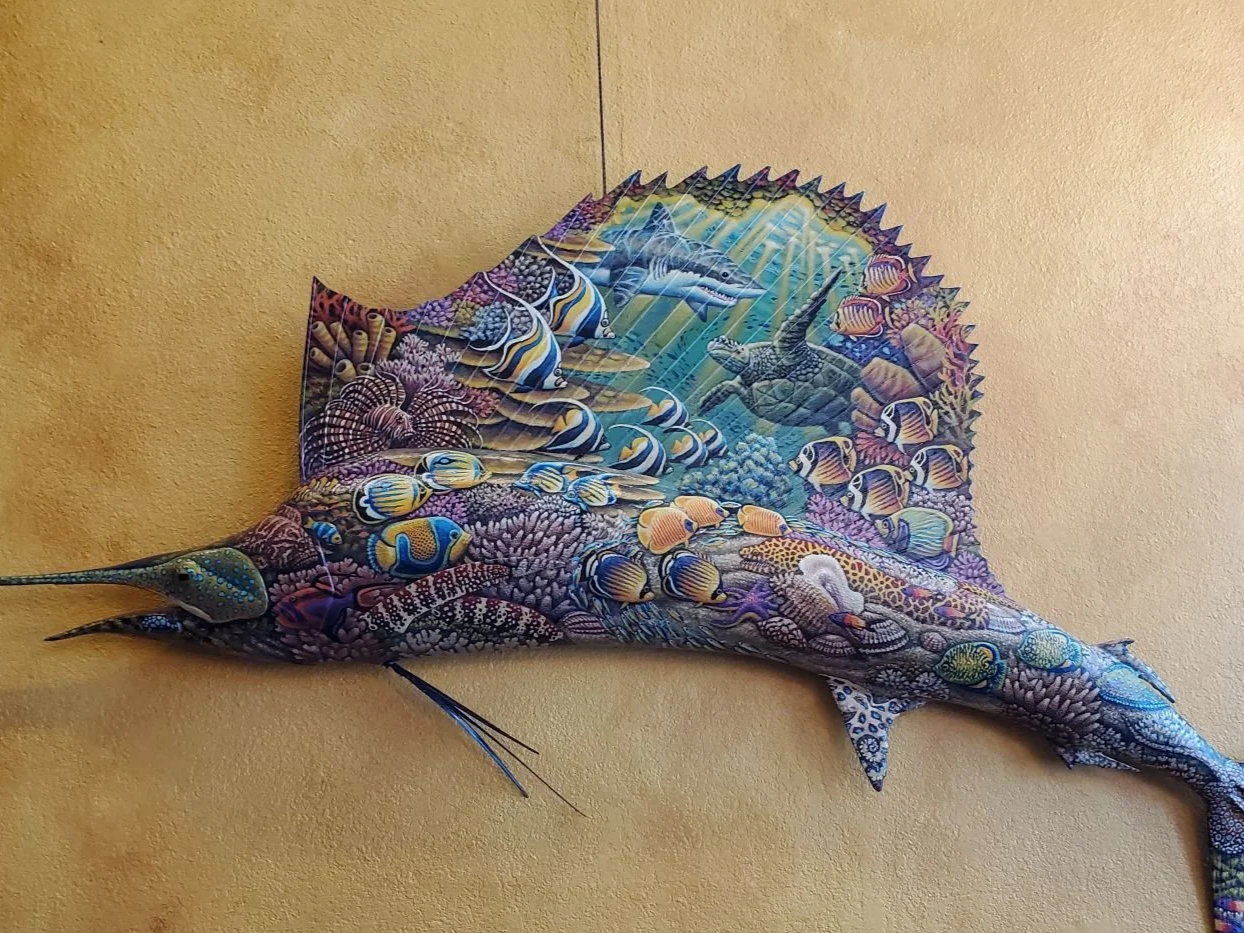 Swordfish with an underwater reef scene and tropical fish painted on it.