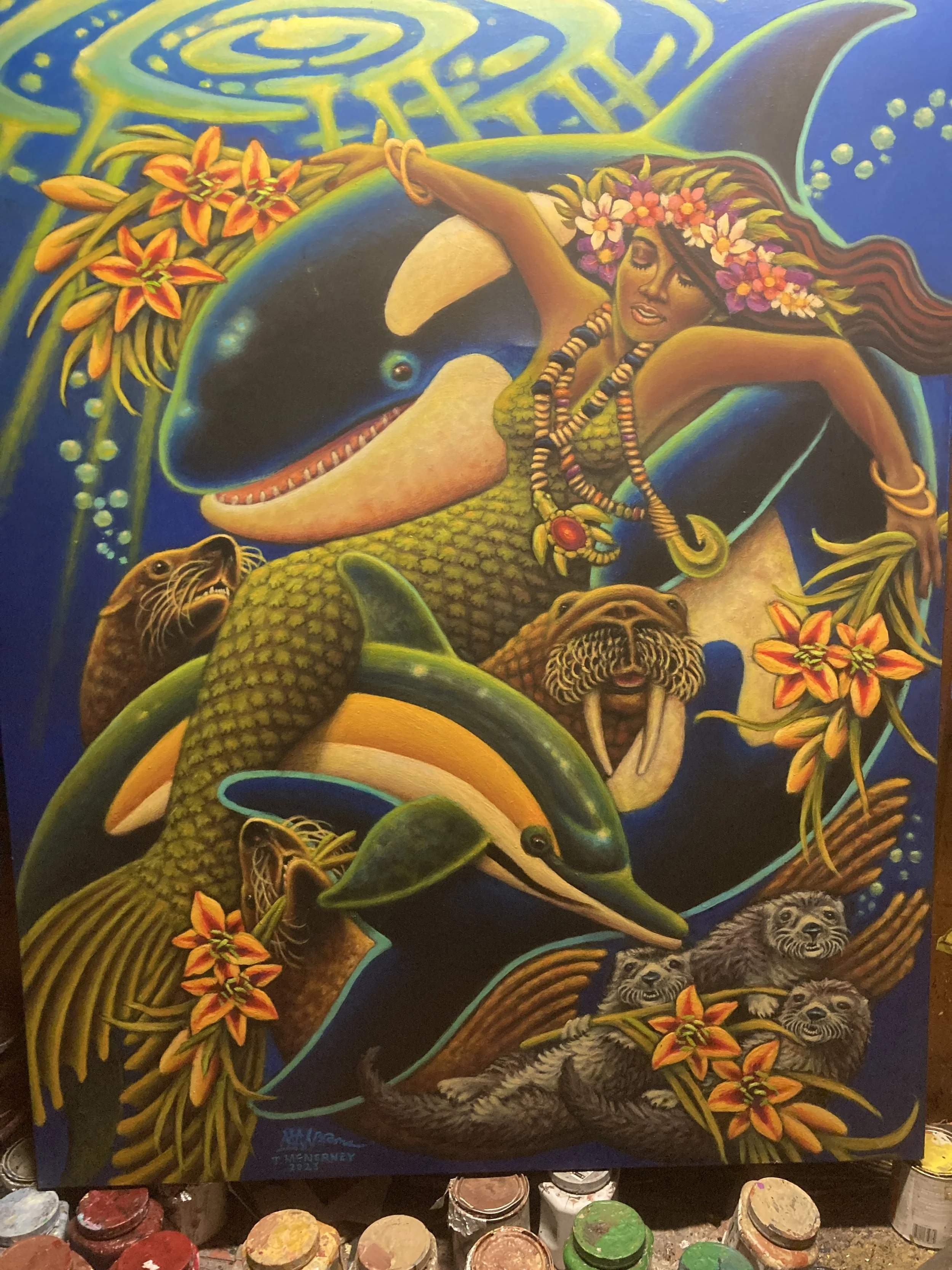 A colorful painting of a woman with mermaid features, a floral headdress, and jewelry, surrounded by dolphins, sea lions, otters, and vibrant tropical flowers underwater.