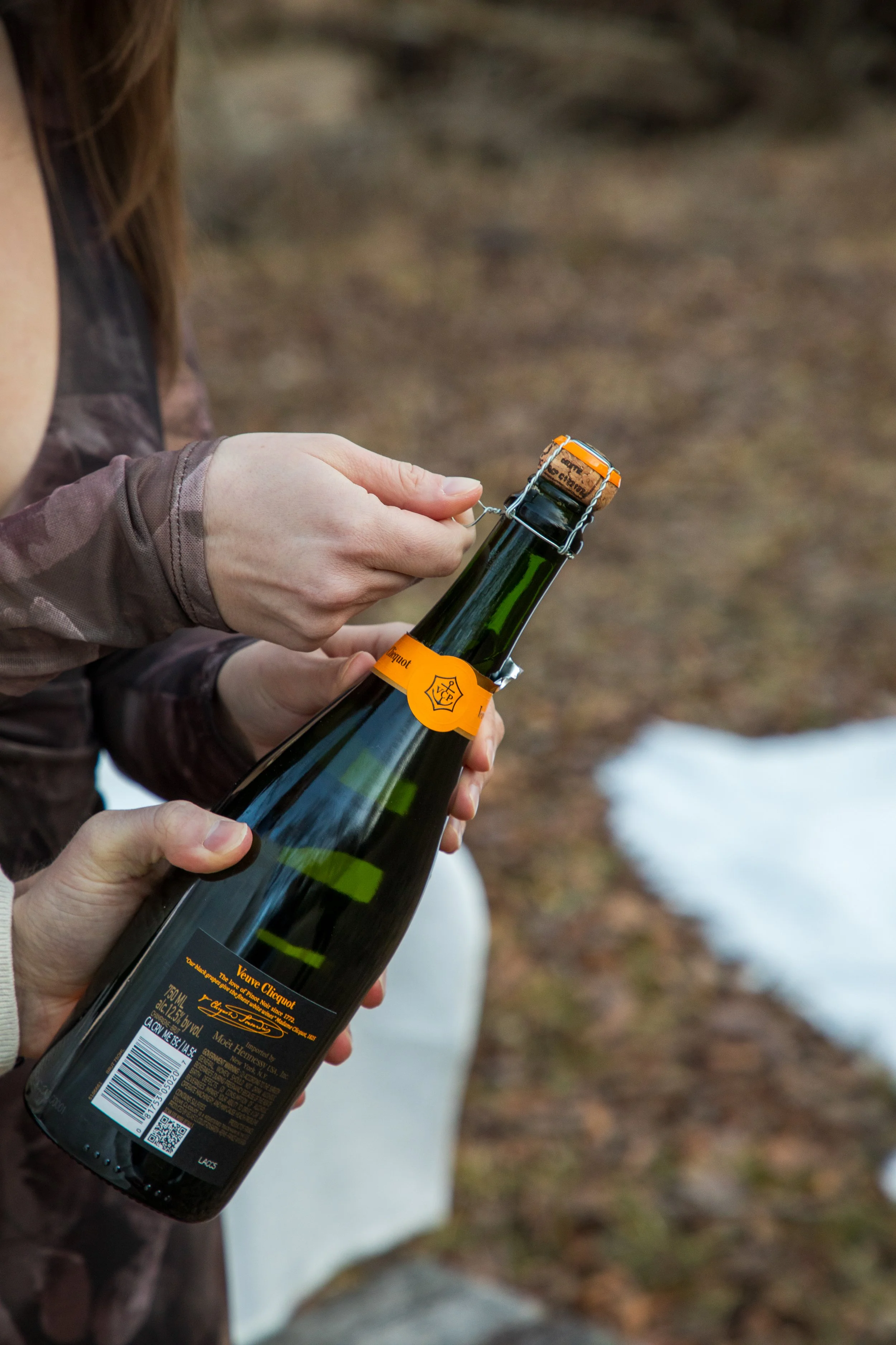 Engagement Photography by Will Locke near Richmond, VA in Montpelier. A bottle of Veuve Clicquot champagne is being opened by a couple.