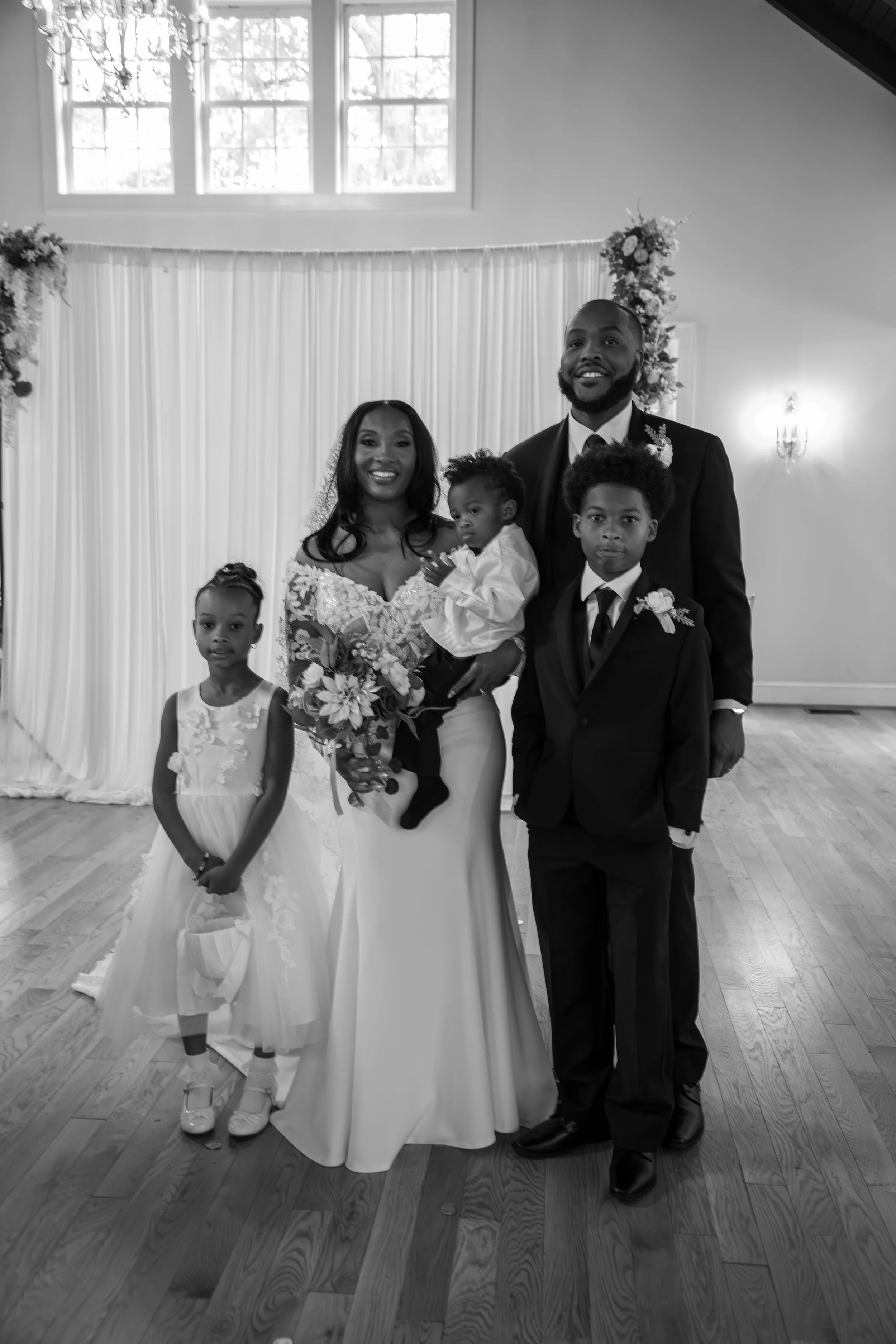 Photo & Video by Will Locke Wedding Photography at the Woman's Club of Portsmouth in Virginia. A black-and-white photo of a family gathered at a wedding celebration.