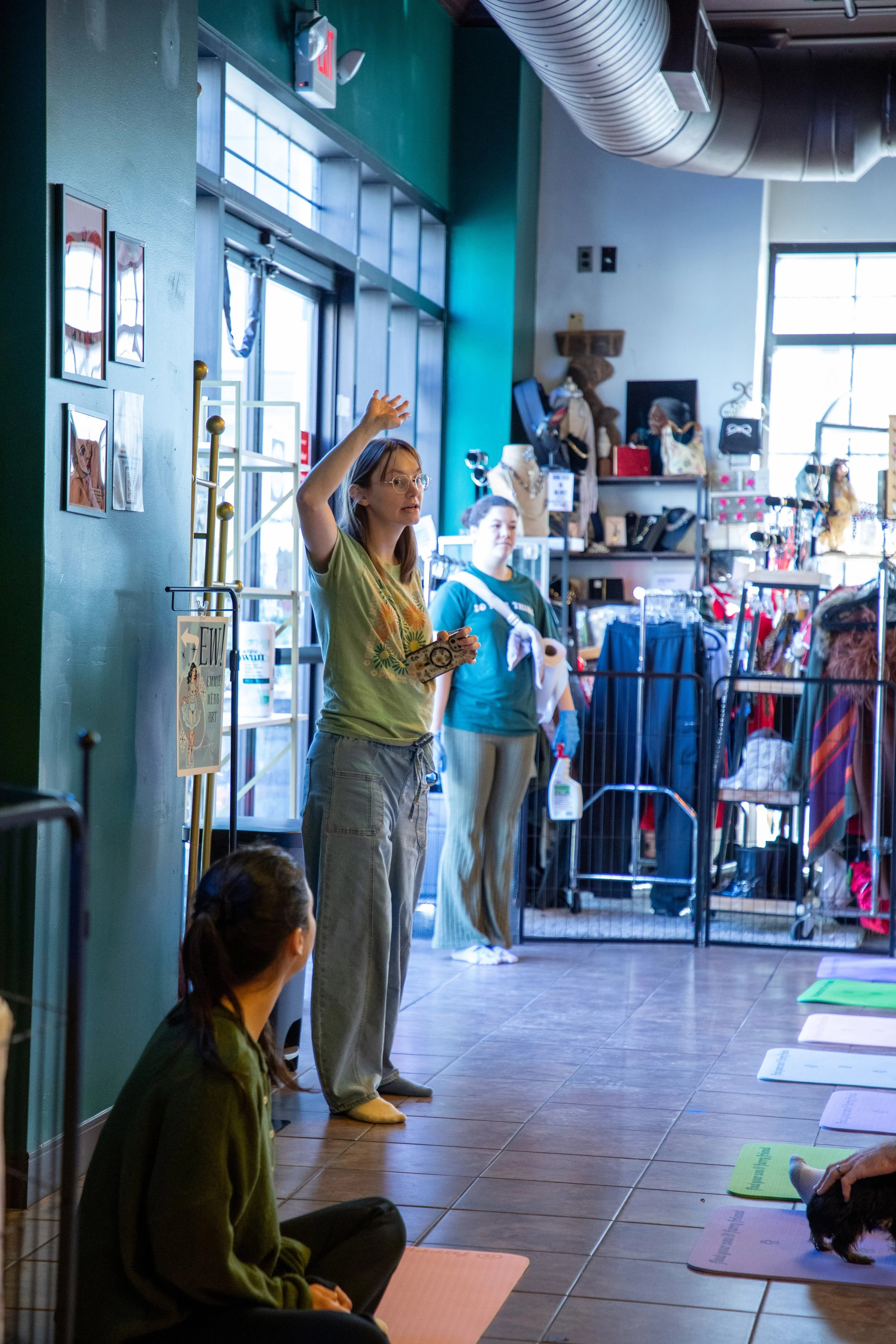 Marketing and Event Photography by Will Locke. Women leading a meditation or yoga class inside a pet store, with some people sitting on mats on the floor.