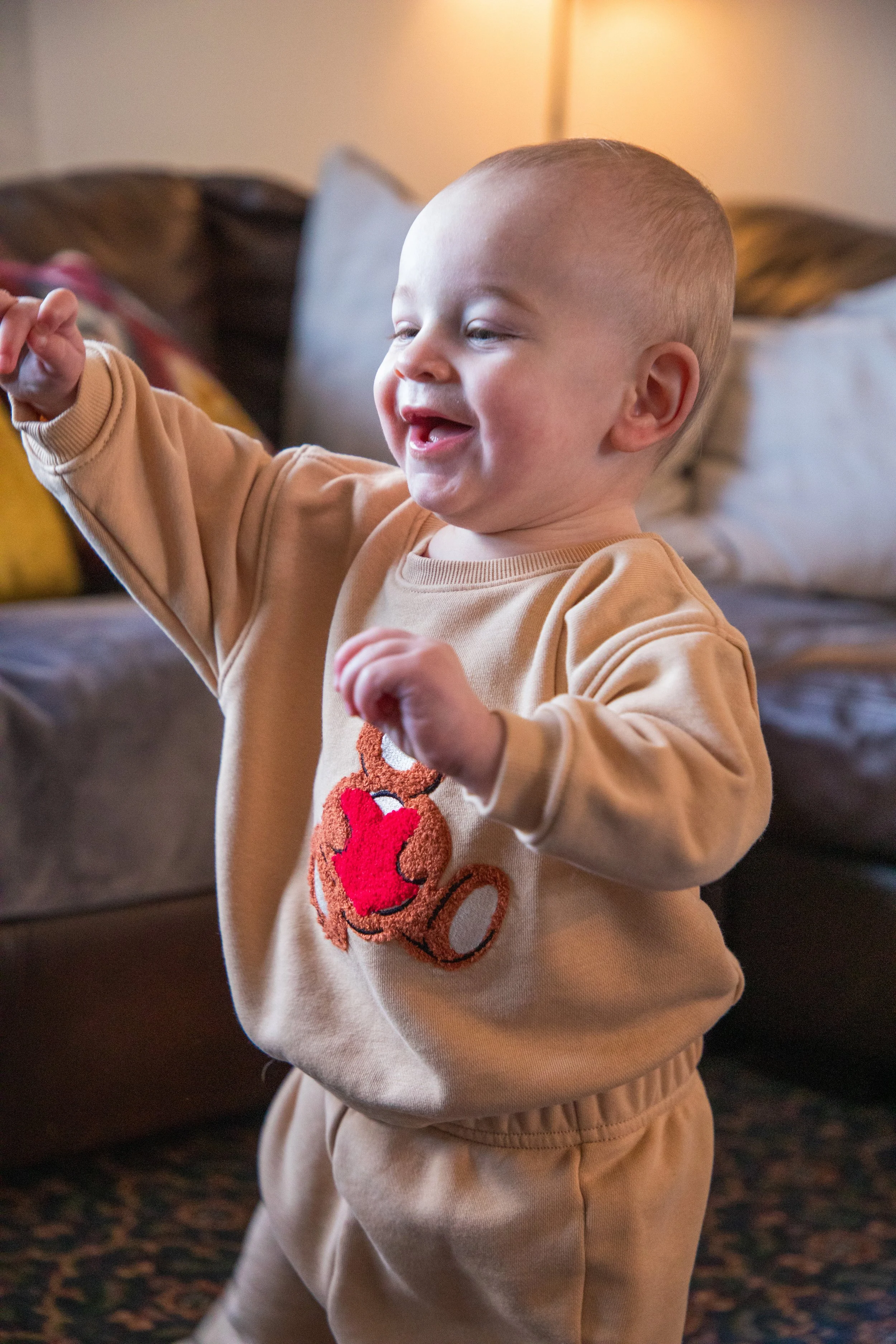 Baby Photography by Will Locke. A young boy with short blonde hair smiling and playing indoors