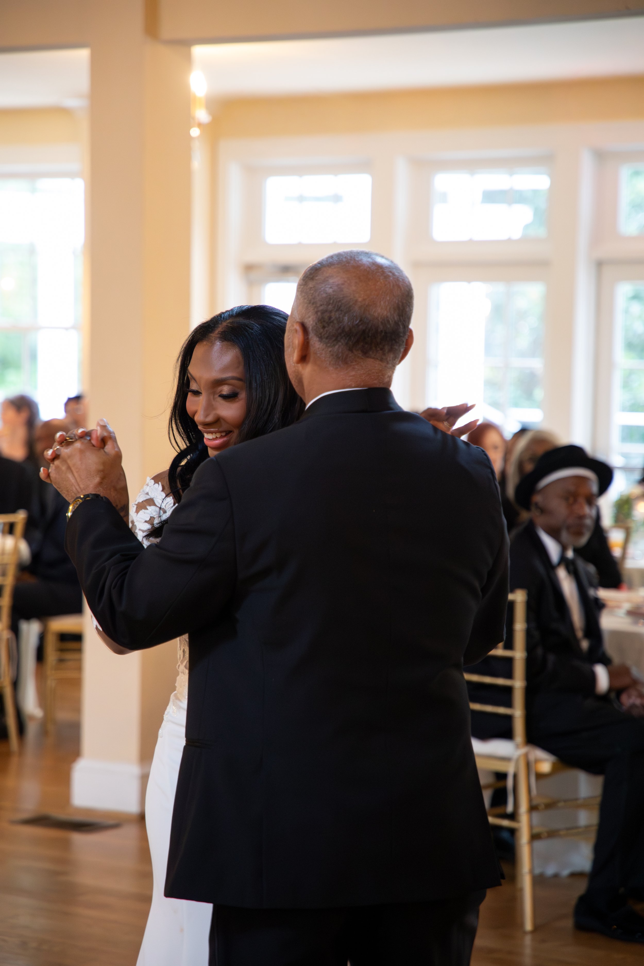 Wedding Photography by Will Locke. A woman in a wedding dress dancing with an older man in a black suit at a celebration event.