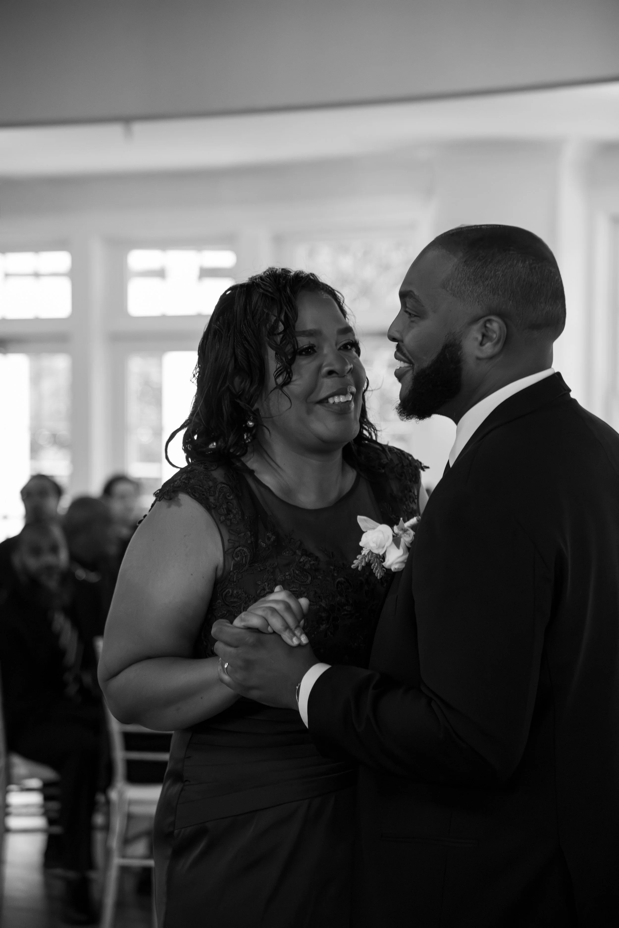 Wedding Photography by Will Locke. A woman and a man dance together at a wedding reception, smiling at each other.