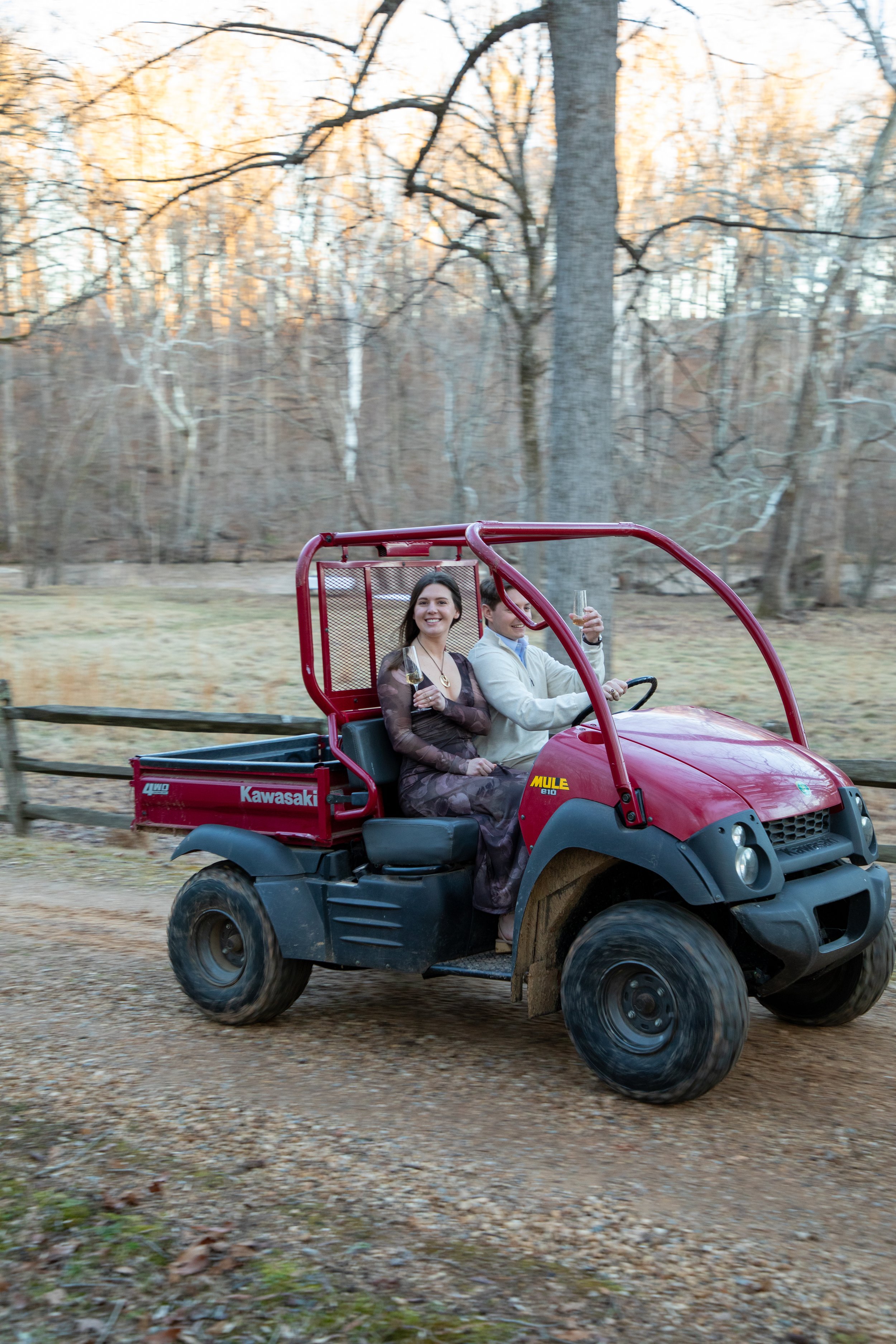Engagement Photography by Will Locke near Richmond, VA in Montpelier. A newly engaged couple riding a red Kawasaki Mule utility vehicle.