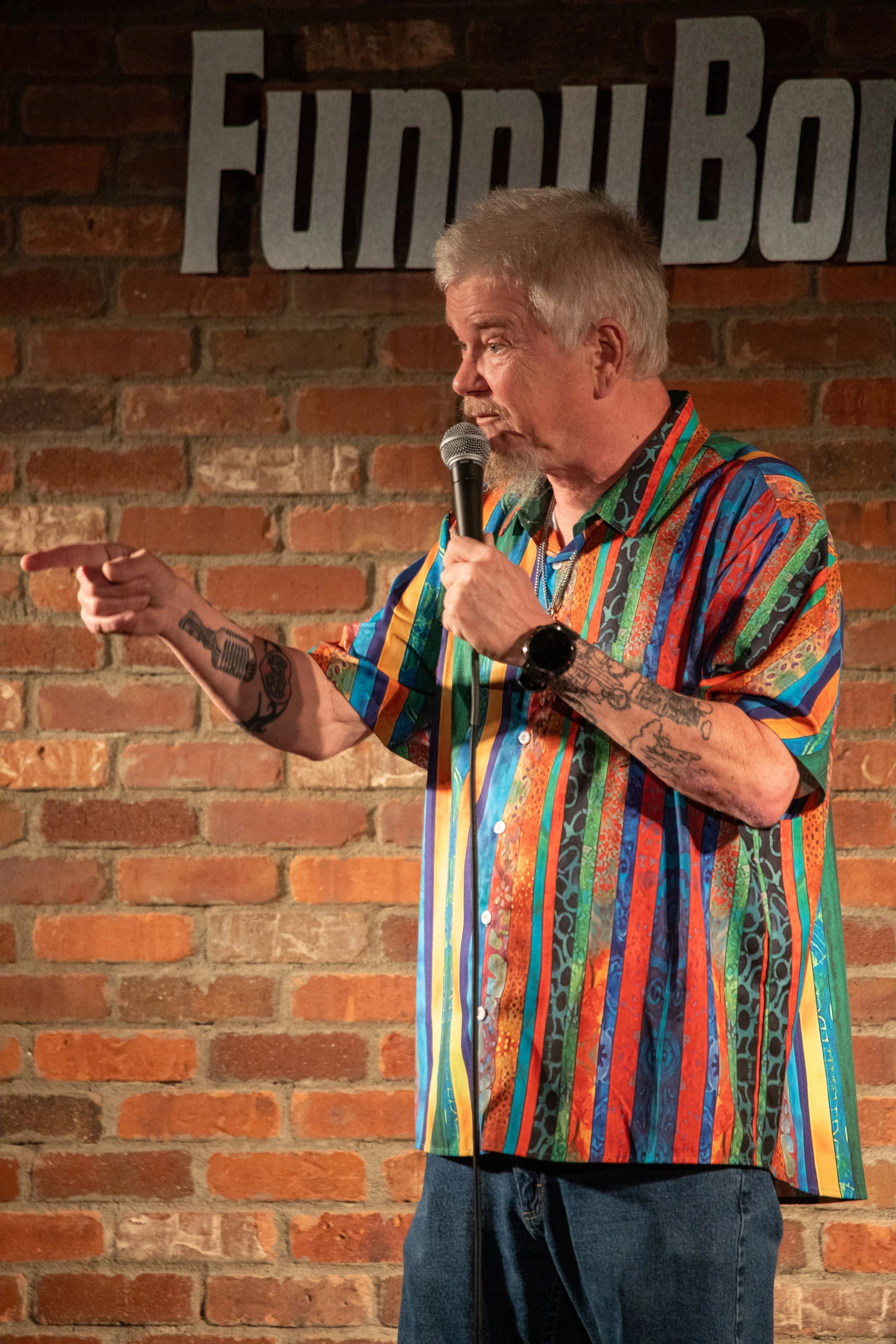 Comedy Photography by Will Locke in Norfolk, VA. Male comedian points at crowd member off screen while performing on stage.